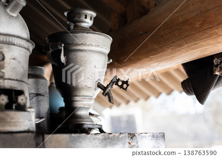 Old metal scene. Vintage metal tap hidden beneath sunlit wooden shelter with aging patina Old metal scene. Vintage metal tap hidden beneath sunlit wooden shelter with aging patina 138763590
