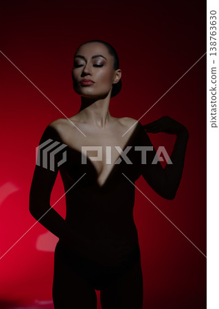 Elegant nude portrait of a woman against a vibrant red backdrop Elegant nude portrait of a woman against a vibrant red backdrop 138763630