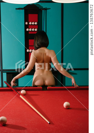 Bare woman playing pool in game room at night 138763672
