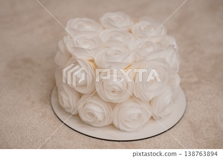Elegant white wedding cake decorated with delicate sugar roses on a simple stand for celebration photography 138763894