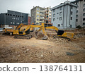 Two yellow excavators working at a city construction site 138764131