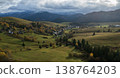 Aerial view on picturesque green valley with small village and snowy mountains in backdrop, Slovakia 138764203