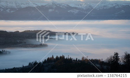 Sunrise landscape with valley full of inversion fog and snowy mountains in the background, Slovakia Sunrise landscape with valley full of inversion fog and snowy mountains in the background, Slovakia 138764215