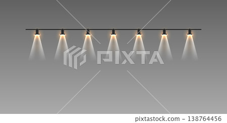 Row of track spotlights illuminating space with warm light beams 138764456
