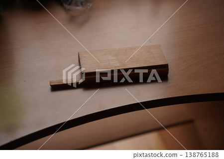 Small wooden block on a wooden table with a curved dark edge in the foreground 138765188