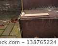 Wooden ruler with white ball on stone steps beside brick pavement with fallen leaves 138765224
