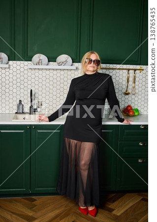 Cheerful woman expressing happiness while preparing meal at home Cheerful woman expressing happiness while preparing meal at home 138765435
