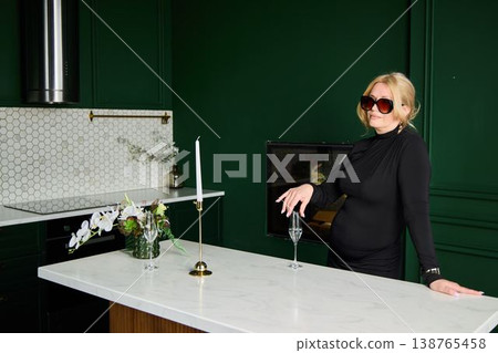 Sophisticated woman posed with glass in upscale environment Sophisticated woman posed with glass in upscale environment 138765458