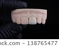 Mirror copy of central maxillary incisor, ultra thin dental ceramic veneer or crown on printed model 138765477