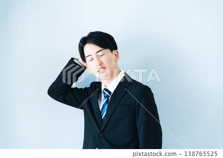 一個身穿西裝的年輕男子雙手抱頭。 138765525