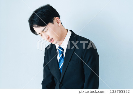 一個身穿西裝的年輕男子雙手抱頭。 138765532