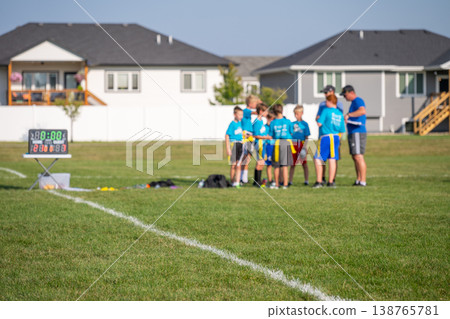 Youth flag football practice in sunny neighborhood park with enthusiastic players and attentive coaches Youth flag football practice in sunny neighborhood park with enthusiastic players and attentive coaches 138765781