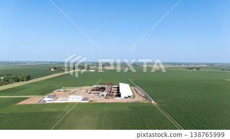 Farmland landscape featuring a large agricultural facility under a clear blue sky in the Midwest during summer Farmland landscape featuring a large agricultural facility under a clear blue sky in the Midwest during summer 138765999