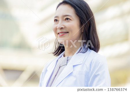 Smiling woman in a white coat 138766374