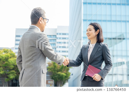 Men and women in suits shake hands 138766450