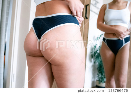 Woman overweight body. Female touching stomach near mirror. Weig Woman overweight body. Female touching stomach near mirror. Weig 138766476