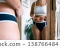 Woman at home. Touching stomach near mirror. Mental health conce 138766484