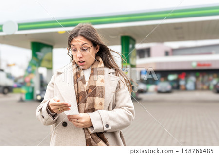 Budget stress young woman calculating petrol costs Budget stress young woman calculating petrol costs 138766485