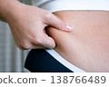 Woman weight check. Female examining torso fat indoors. Self car 138766489