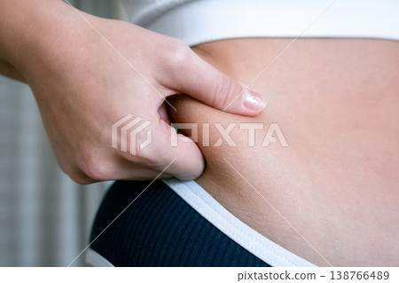 Woman weight check. Female examining torso fat indoors. Self car Woman weight check. Female examining torso fat indoors. Self car 138766489