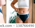 Woman overweight body. Female touching stomach near mirror. Weig 138766490
