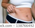 Woman overweight body. Female touching stomach near mirror. Weig 138766492