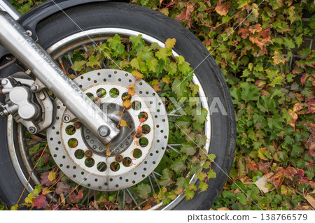 Ivy entwined around an old motorcycle 138766579