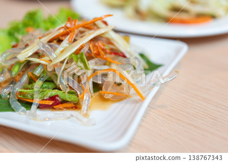 Close up of spicy glass noodle salad with vegetables and chili dressing fresh herbs tangy flavor thai cuisine vibrant color light meal on plate Close up of spicy glass noodle salad with vegetables and chili dressing fresh herbs tangy flavor thai cuisine vibrant color light meal on plate 138767343