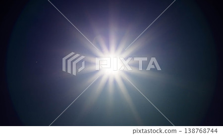A landscape where the sunlight shining brightly in the blue sky appears as rays of light radiating outwards. A landscape where the sunlight shining brightly in the blue sky appears as rays of light radiating outwards. 138768744