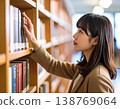 一名女學生在圖書館書架上尋找書籍。 138769064