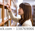 一名女學生在圖書館書架上尋找書籍。 138769066