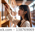 一名女學生在圖書館書架上尋找書籍。 138769069