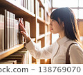 一名女學生在圖書館書架上尋找書籍。 138769070