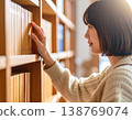 一名女學生在圖書館書架上尋找書籍。 138769074