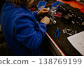 Close-up of hands of young computer engineer fixing broken pc parts at the desk in the home office 138769199