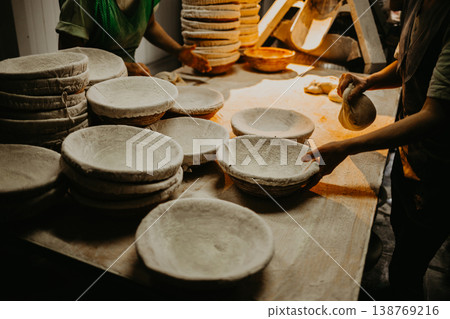 female hands in flour closeup kneading dough on table 138769216