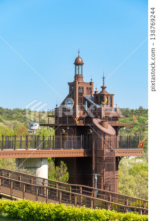 The elevator tower and Howl's Moving Castle at Ghibli Park, surrounded by fresh greenery. The elevator tower and Howl's Moving Castle at Ghibli Park, surrounded by fresh greenery. 138769244