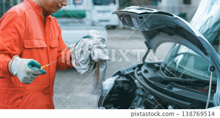 汽車修理工透過檢查機油表來檢查汽車的機油油位。 138769514