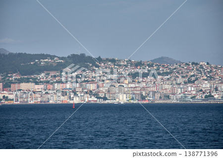 Coastal cityscape of Vigo captured from the center of the Vigo Estuary with a skyline of buildings and a clear sky Coastal cityscape of Vigo captured from the center of the Vigo Estuary with a skyline of buildings and a clear sky 138771396