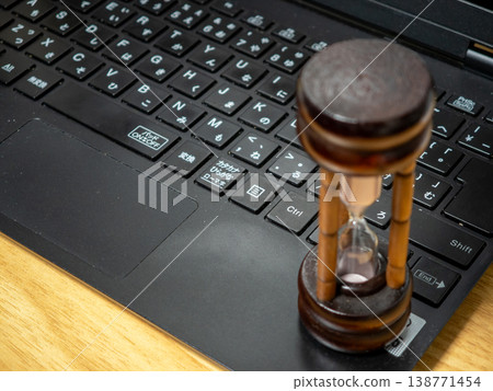 A laptop and an hourglass, the passage of time A laptop and an hourglass, the passage of time 138771454