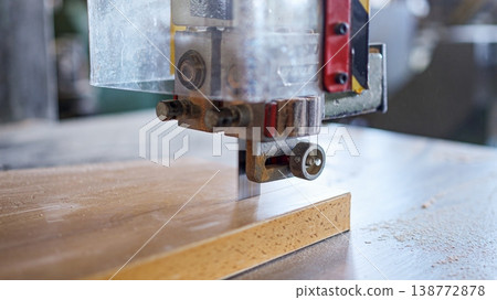 Bandsaw blade cutting wood in a woodworking workshop Bandsaw blade cutting wood in a woodworking workshop 138772878