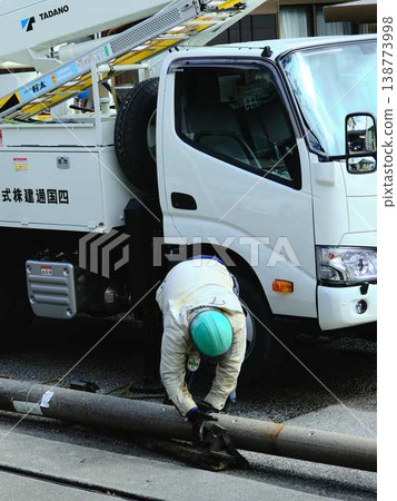 Electrical work on a utility pole in a residential area. Electrical work on a utility pole in a residential area. 138773998