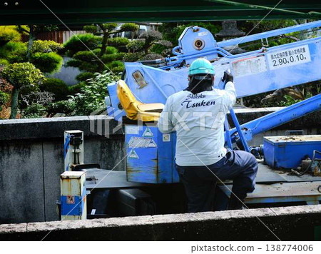 Electrical work on a utility pole in a residential area. 138774006
