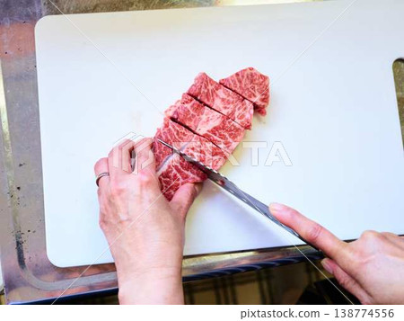 A female chef cutting domestically produced Japanese Black beef thigh meat 138774556