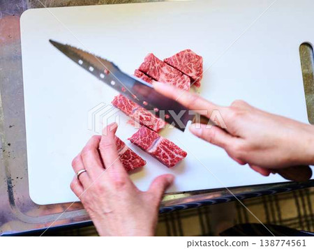 一位女廚師正在切割國產日本黑毛牛腿肉 一位女廚師正在切割國產日本黑毛牛腿肉 138774561