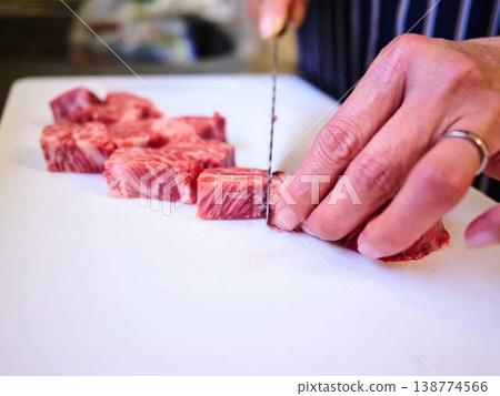 一位女廚師正在切割國產日本黑毛牛腿肉 一位女廚師正在切割國產日本黑毛牛腿肉 138774566