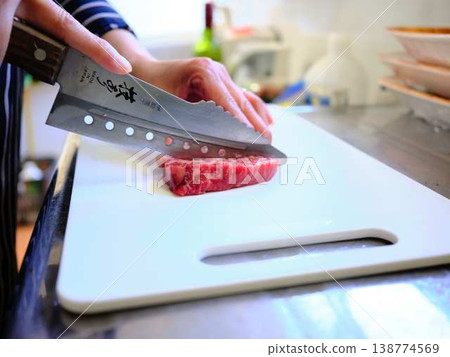 A female chef cutting domestically produced Japanese Black beef thigh meat 138774569