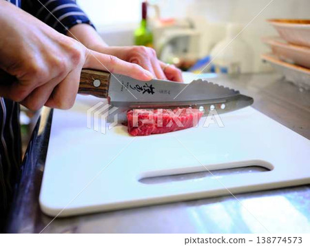 A female chef cutting domestically produced Japanese Black beef thigh meat A female chef cutting domestically produced Japanese Black beef thigh meat 138774573