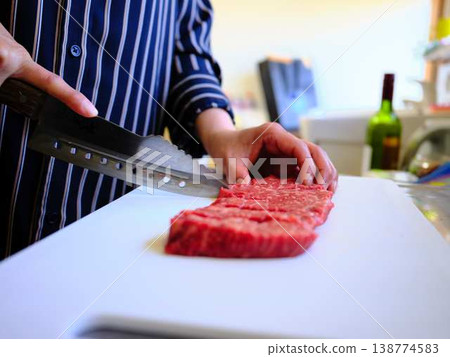 A female chef cutting domestically produced Japanese Black beef thigh meat 138774583