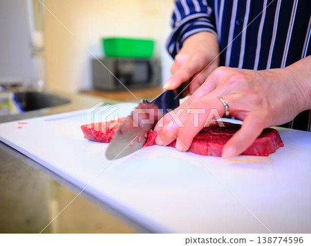 一位女廚師正在切割國產日本黑毛牛腿肉 一位女廚師正在切割國產日本黑毛牛腿肉 138774596
